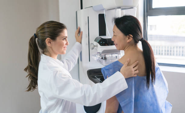Woman receiving mammo scan with reassuring doctor